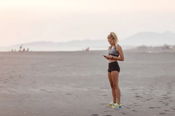Красиві Кавказьких Жінка Бігун Стоячи Піщаний Пляж Набравши Мобільний Телефон — стокове фото