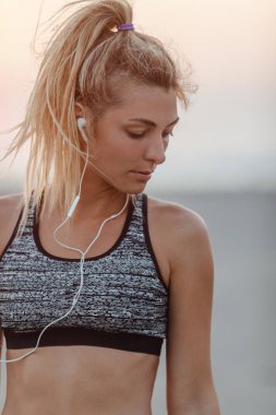 Earphones ile ayakta çok kafkas kadın runner.