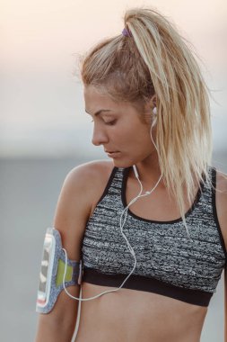 Earphones ile ayakta çok kafkas kadın runner.