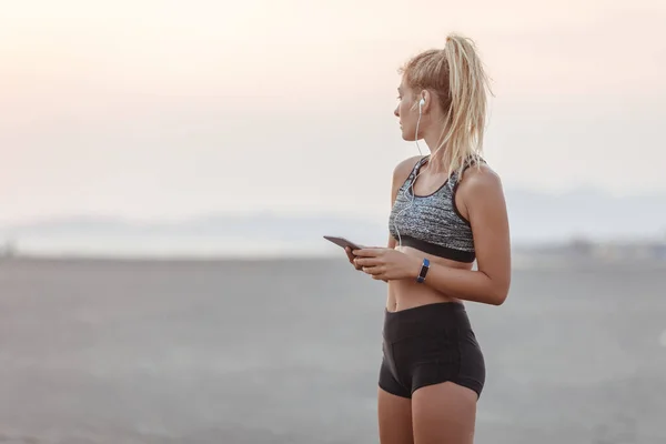 Krásné Kavkazský Žena Běžec Písčité Pláži Drží Její Mobilní Telefon — Stock fotografie
