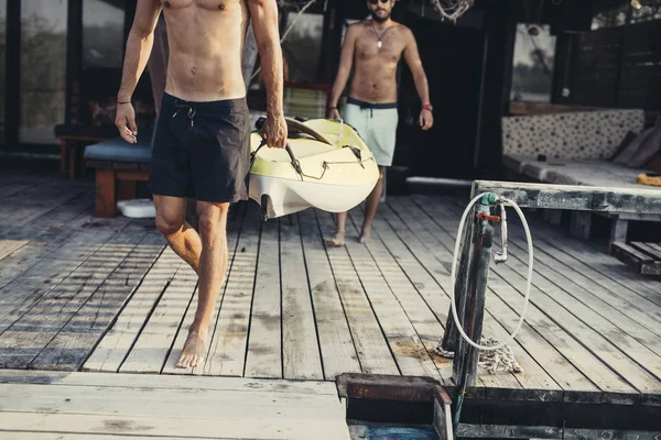 Dois Homens Irreconhecíveis Carregando Uma Canoa Convés Madeira — Fotografia de Stock