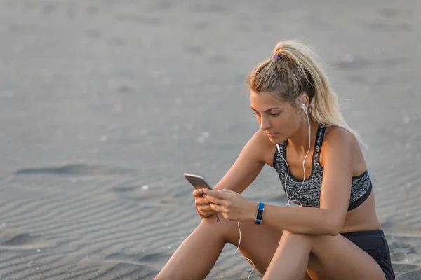 Pěkně Kavkazské Sportovkyně Sedí Písečné Pláži Drží Její Mobilní Telefon — Stock fotografie
