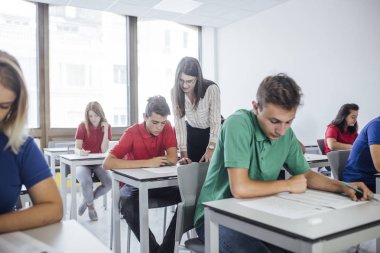 Bir öğrenci için bir sınav sırasında yardımcı bir kadın öğretmen.