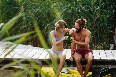 Genç adam ve cep telefonu kamera ile selfie alarak ve yaz Nehri üzerinde zevk kadın.