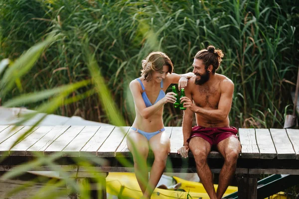 Genç adam ve cep telefonu kamera ile selfie alarak ve yaz Nehri üzerinde zevk kadın.