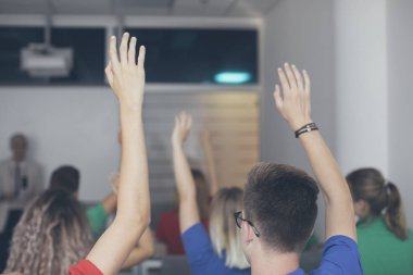 Grup bilirler ve eller yükselen kız öğrenciler bu soruyu cevaplamak için.