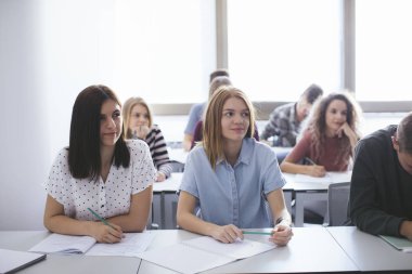 Sınıf oturan kız öğrenciler ve öğrenciler genç grup.