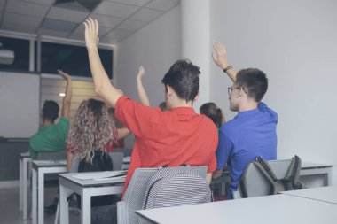 Grup bilirler ve eller yükselen kız öğrenciler bu soruyu cevaplamak için.