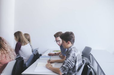 Sınıf oturan kız öğrenciler ve öğrenciler genç grup.