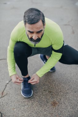 Yakışıklı orta yaşlı beyaz adam atlet bir bağcık bağlama.