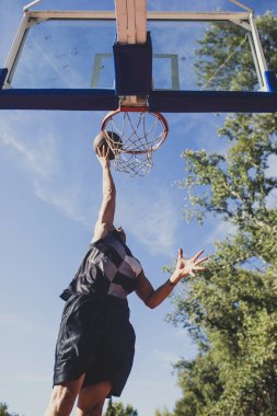 Genç beyaz adam eğitim basketbol açık mahkemede.