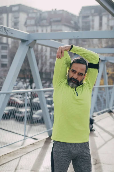 Bonito Homem Caucasiano Meia Idade Corredor Ponte Fazendo Exercício Alongamento — Fotografia de Stock