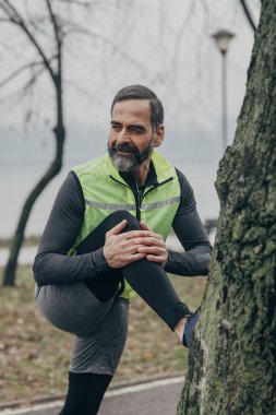 Sabah rekreasyon zevk ve bacaklarını esnetiyor yakışıklı orta yaşlı beyaz adam.