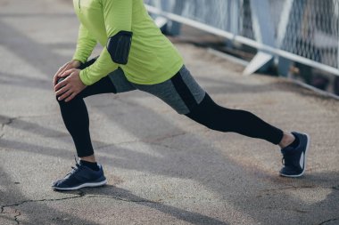 Açık havada germe egzersiz yaparak unrecognisable sporcu.