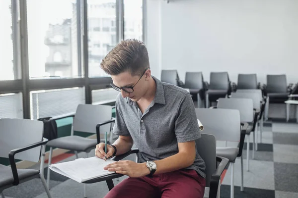 Estudante Ensino Médio Sentado Sala Aula Moderna Escrevendo Seu Caderno — Fotografia de Stock