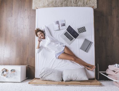 Onu cep telefonundan konuşuyor ve yatakta yatarken kadın fotoğrafı yukarıda.