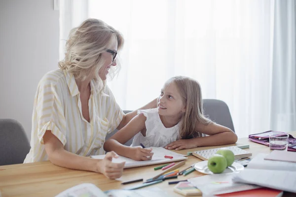 Schöne Kaukasische Frau Und Niedliche Blonde Lächelnde Schulmädchen Hausaufgaben Zusammen — Stockfoto