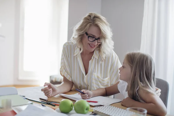 Schöne Lächelnde Kaukasische Frau Und Niedliche Blonde Schulmädchen Hausaufgaben Zusammen — Stockfoto