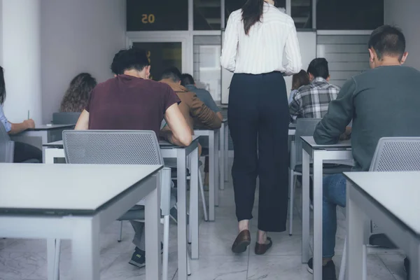 Professor Olhando Para Alunos Ensino Médio Enquanto Faz Exame — Fotografia de Stock