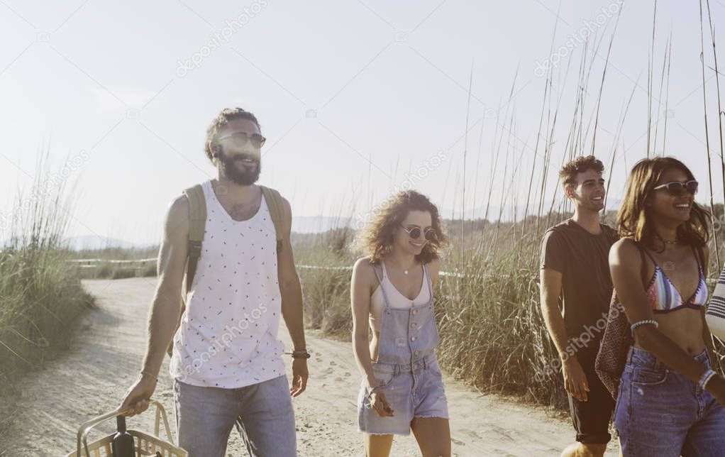 Group of young men and women on vacation going to picnic,