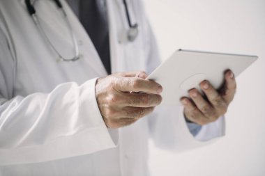 Eller unrecognisable adam hekim holding Tablet.