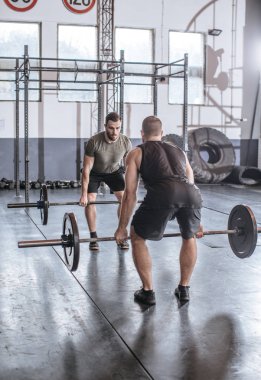 İki sporcu spor salonunda ağırlık togethrt kaldırma.