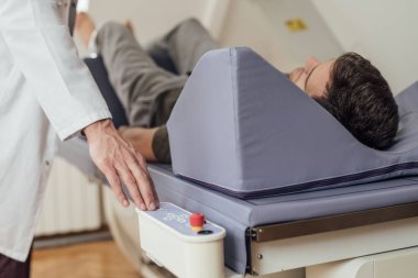Onun hasta yatakta yatarken kemik Densitometre işletim bir tıbbi teknisyen eli.