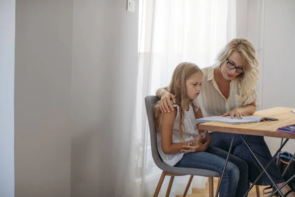 可爱的金发白人女学生做家庭作业与她的母亲帮助 — 图库照片