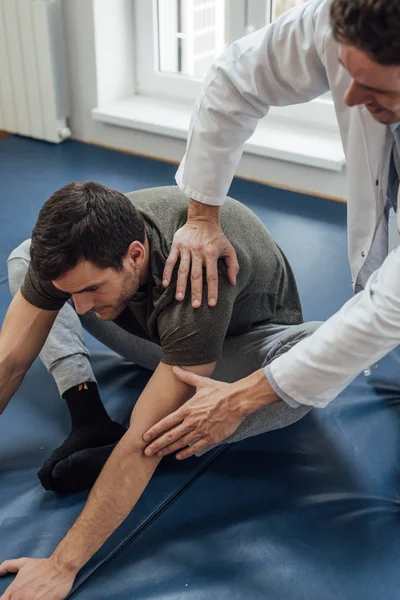 Ung Snygg Kaukasiska Man Stretching Hans Rygg Med Hans Läkare — Stockfoto