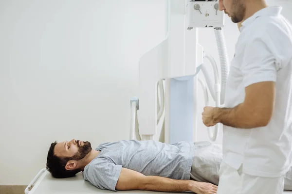 Fiatal Orvosi Technikus Működő Egy Röntgengép Miközben Beteg Fekszik Előtte — Stock Fotó