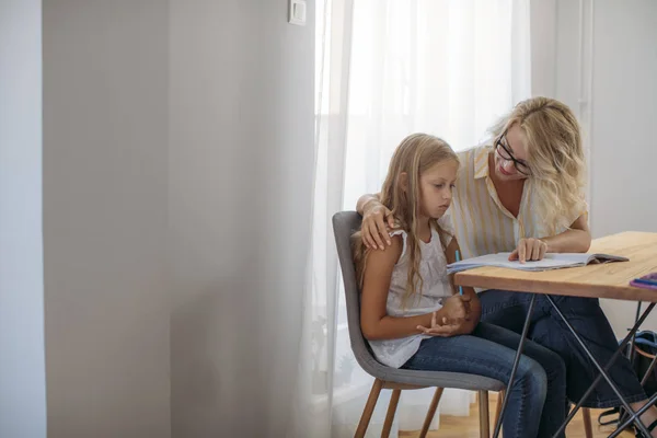 かわいい金髪白人女子高生を助ける彼女の母親と一緒に宿題 — ストック写真