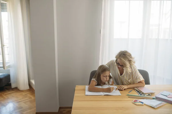 Ładna Blondynka Pisanie Notesie Siedzący Obok Jej Mama — Zdjęcie stockowe