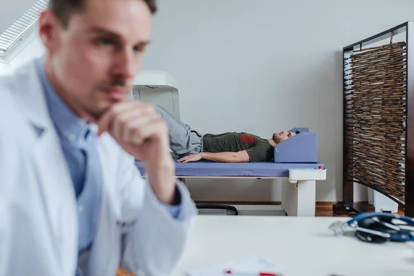 Joven Técnico Médico Caucásico Escribiendo Diagnóstico Mientras Paciente Está Acostado — Foto de Stock