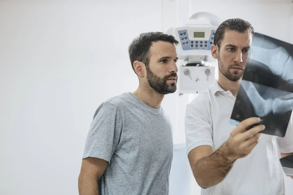 Jovem Médico Seu Paciente Examinando Filmes Raios Uma Clínica — Fotografia de Stock