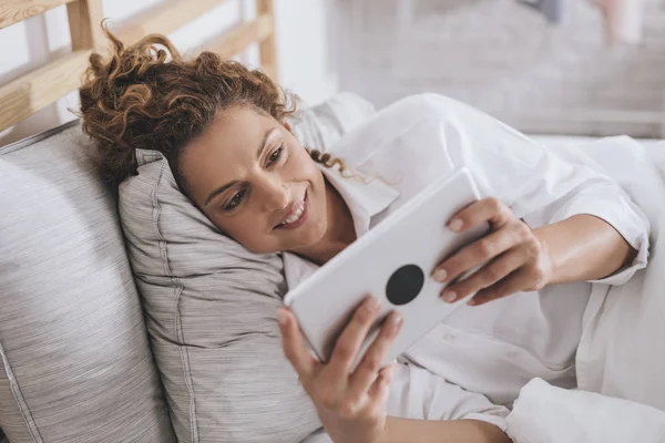 Mulher Branca Muito Sorridente Deitada Sua Cama Lendo Tablet — Fotografia de Stock