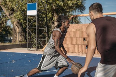 Açık havada basketbol oynarken iki yakışıklı erkekler.