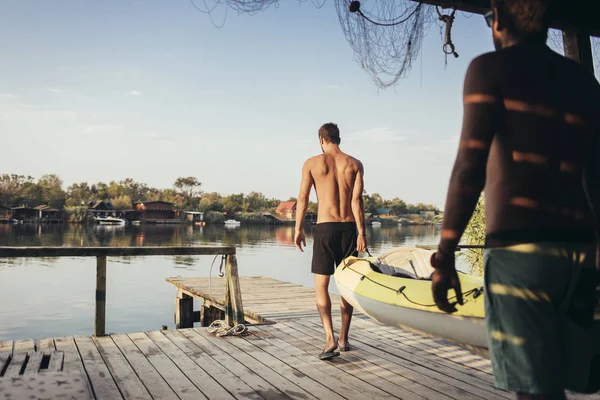 Dos Jóvenes Llevando Kayak Sobre Los Muelles Madera — Foto de Stock