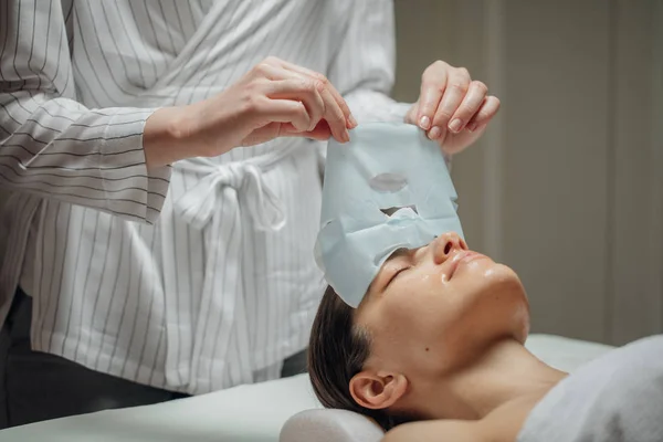 Mulher Cosmetologista Caucasiana Colocando Uma Máscara Facial Rosto Uma Bela — Fotografia de Stock