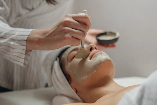 Donna Cosmetologa Caucasica Che Applica Una Maschera Facciale Sul Viso — Foto Stock