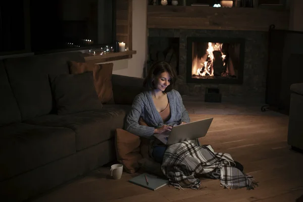 Beautiful Smiling Woman Sitting Fireplace Wooden Floor Typing Her Laptop — Stock Photo, Image