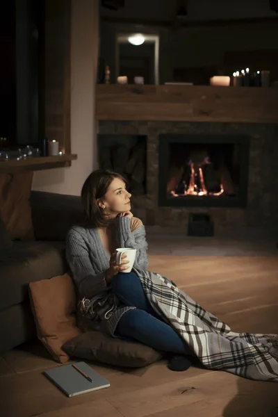 Piękna Kobieta Siedząc Przy Kominku Przytulnym Sweter Patrząc Zrelaksowany — Zdjęcie stockowe