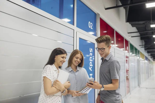 Grupp Leende Gymnasieelever Som Står Korridoren Skolan Och Tittar Mobilen — Stockfoto