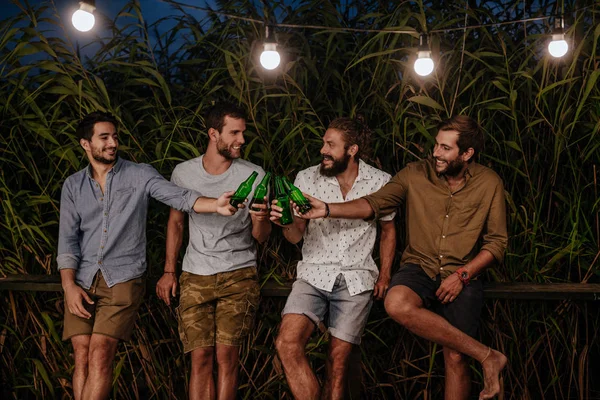 若い男性が屋外と飲むビールをぶら下げを笑顔のグループ — ストック写真