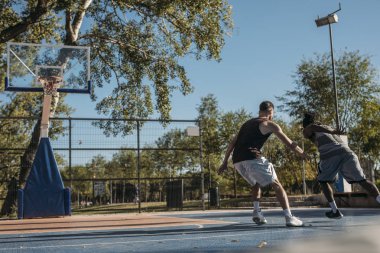 Açık havada basketbol oynarken iki yakışıklı erkekler.