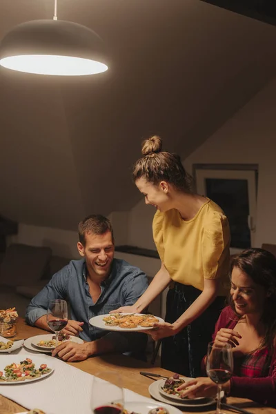 Junge Frau Serviert Leckeres Essen Auf Ihrer Dinnerparty — Stockfoto