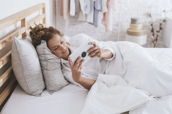 Pretty Smiling Caucasian Woman Lying Her Bed Reading Her Tablet — Stock Photo, Image