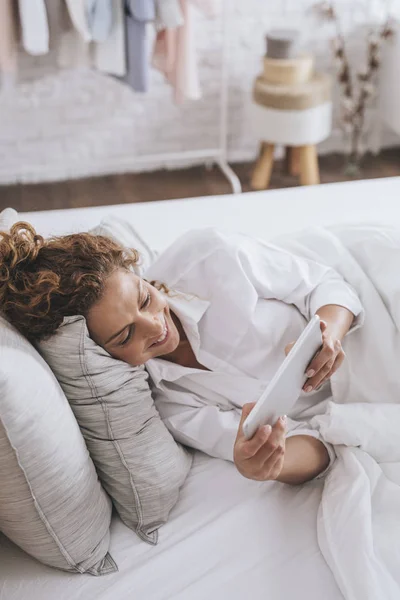 Pretty Smiling Caucasian Woman Lying Her Bed Reading Tablet — Stock Photo, Image