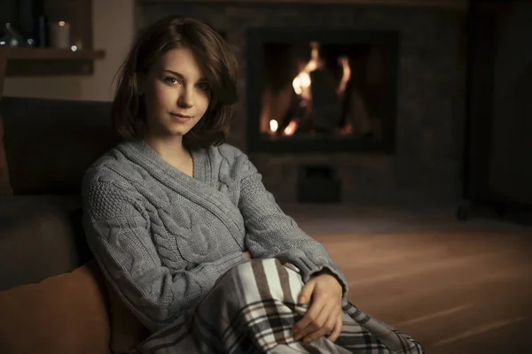 美しい白人女性暖炉のそばに座って カメラ目線 — ストック写真