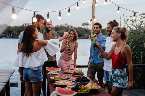 川沿いの屋外パーティーを持つ若い人々 のグループ — ストック写真