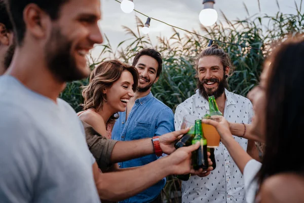 Groupe Jeunes Ayant Dîner Plein Air Bord Rivière Bouteilles Montantes — Photo